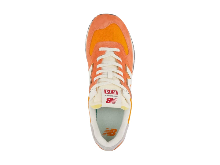 Tenis New Balance modelo 574 en color naranja atómico con detalles en blanco y gris.