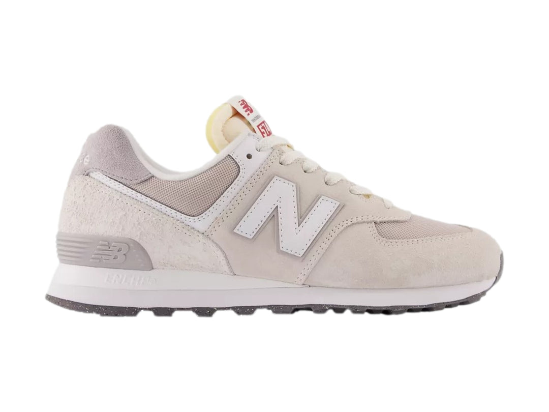 Tenis New Balance 574 en color gris alloy y blanco, vista lateral sobre fondo blanco.