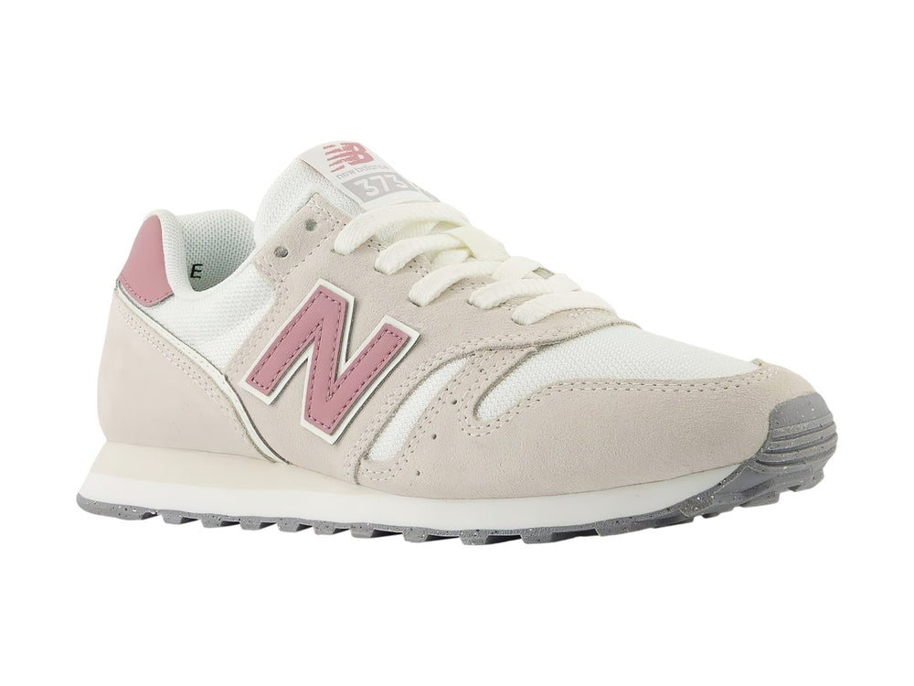 Tenis New Balance 373 color beige con detalles en rosa y suela blanca y gris.