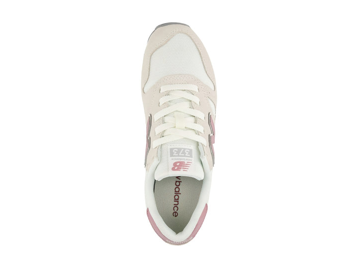 Tenis New Balance 373 color beige con detalles en rosa y suela blanca y gris.