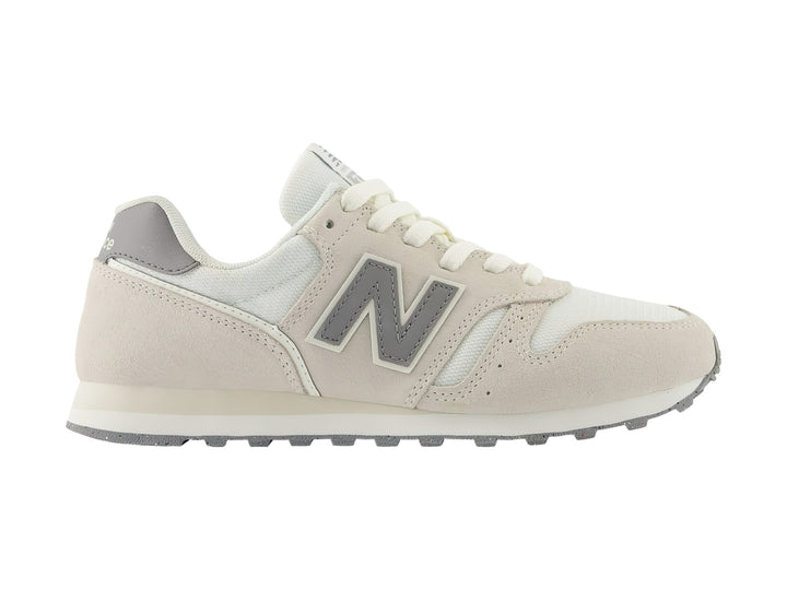 Tenis New Balance 373 color beige Moonbeam con detalles en gris y suela blanca.