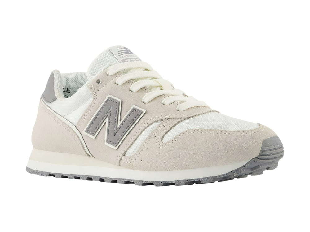 Tenis New Balance 373 color beige Moonbeam con detalles en gris y suela blanca.