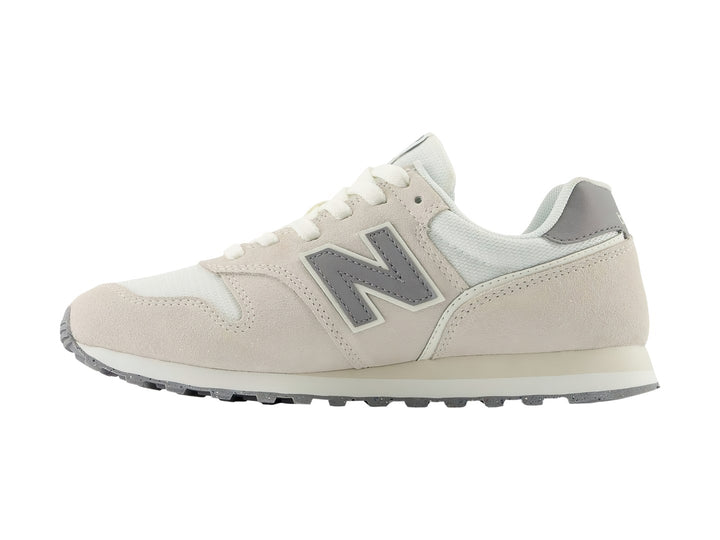 Tenis New Balance 373 color beige Moonbeam con detalles en gris y suela blanca.