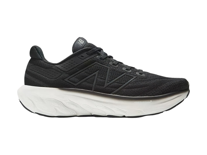 Tenis New Balance deportivos en color negro con suela blanca, vista lateral.