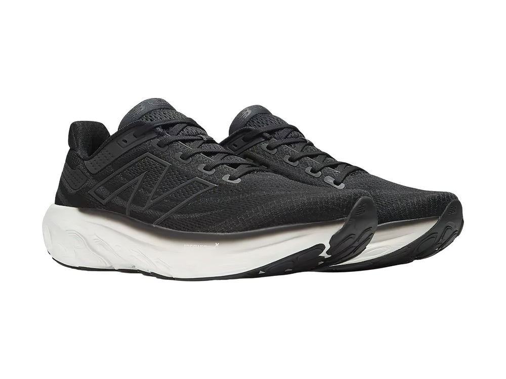 Tenis New Balance deportivos en color negro con suela blanca, vista lateral.
