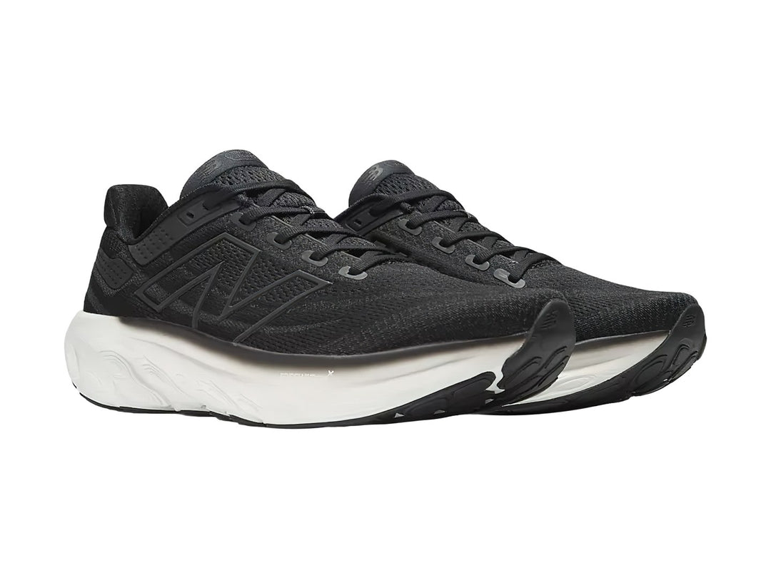 Tenis New Balance deportivos en color negro con suela blanca, vista lateral.