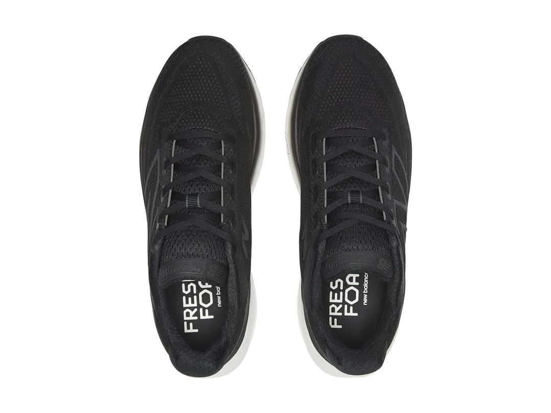 Tenis New Balance deportivos en color negro con suela blanca, vista lateral.