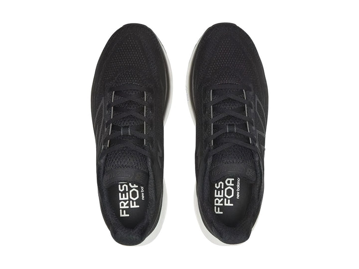 Tenis New Balance deportivos en color negro con suela blanca, vista lateral.