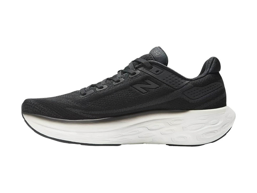 Tenis New Balance deportivos en color negro con suela blanca, vista lateral.