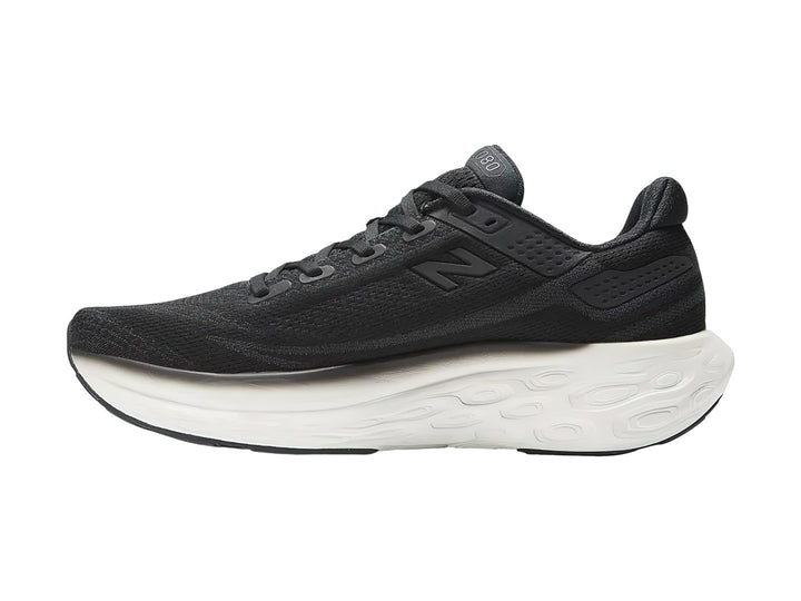 Tenis New Balance deportivos en color negro con suela blanca, vista lateral.