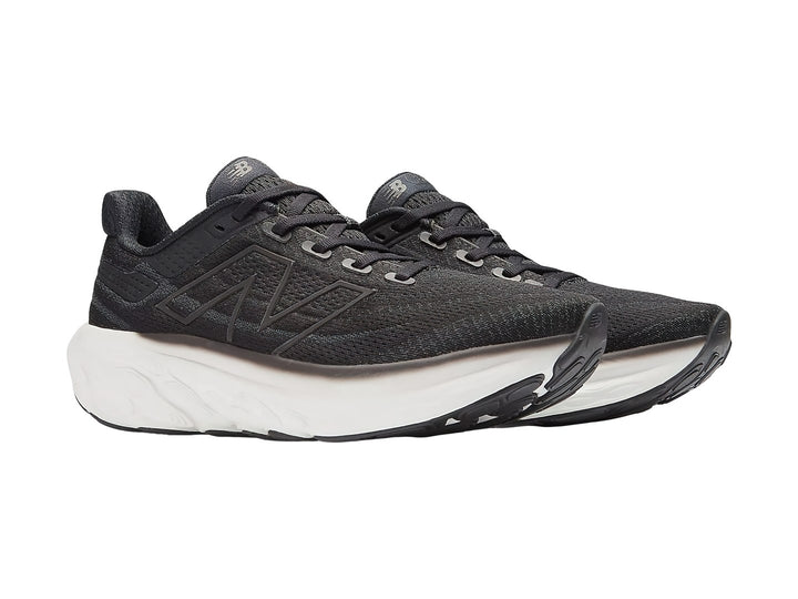 Tenis New Balance color negro con suela blanca gruesa para correr.