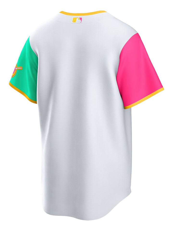 Jersey de béisbol Nike San Diego Padres blanco con mangas rosa y verde y letras multicolores en el pecho.