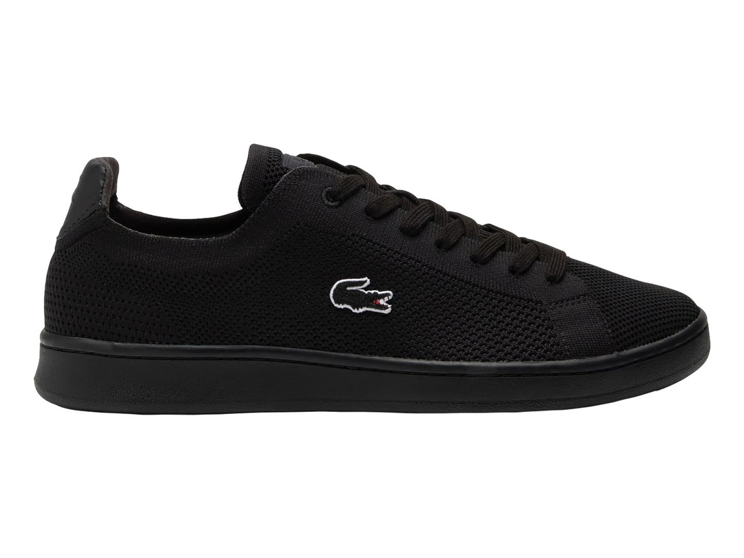 Tenis negros Lacoste de material textil con suela negra y logotipo blanco lateral.