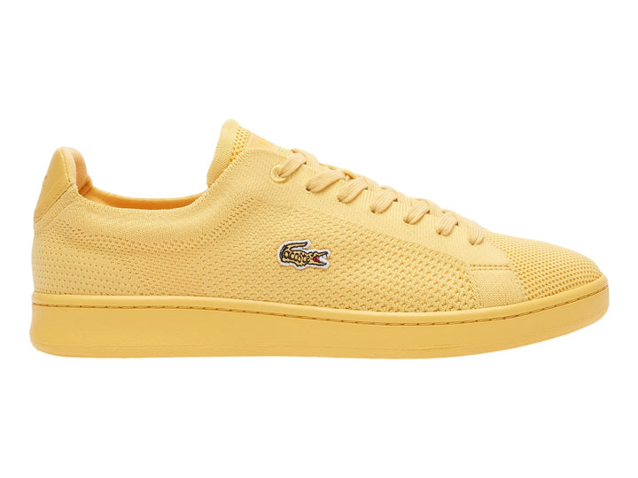 Tenis amarillos Lacoste con textura de piqué y suela plana.