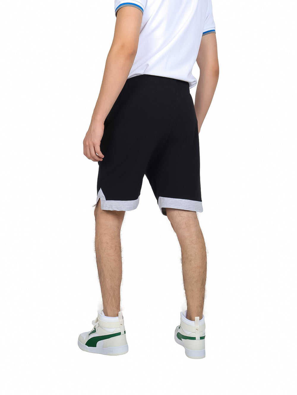 Hombre vistiendo shorts deportivos K-Swiss color negro con detalle gris en el borde inferior.