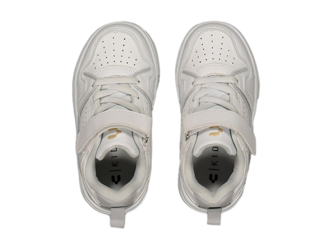 Tenis deportivos blancos con cierre de velcro y logotipo dorado en el lateral.