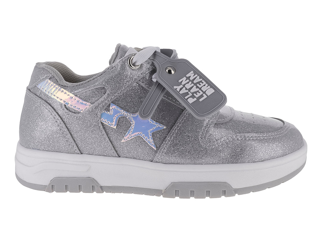 Tenis deportivos color plata con acabado brillante y correa con el texto 'PLAY LEARN DREAM'.