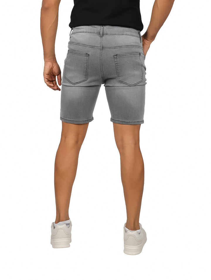 Hombre vistiendo bermudas de mezclilla color negro deslavado.