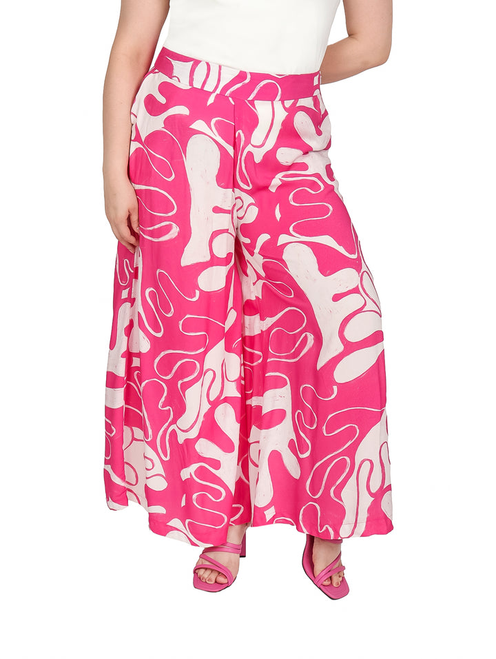 Pantalón pata elefante color fucsia con estampado abstracto en blanco.