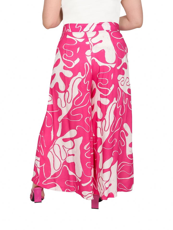 Pantalón pata elefante color fucsia con estampado abstracto en blanco.