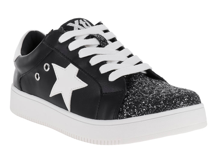 Tenis negros infantiles con estrella blanca, punta brillante y suela blanca.