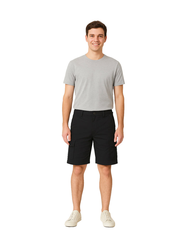 Hombre vistiendo shorts negros de surf con bolsillos laterales sobre fondo blanco.