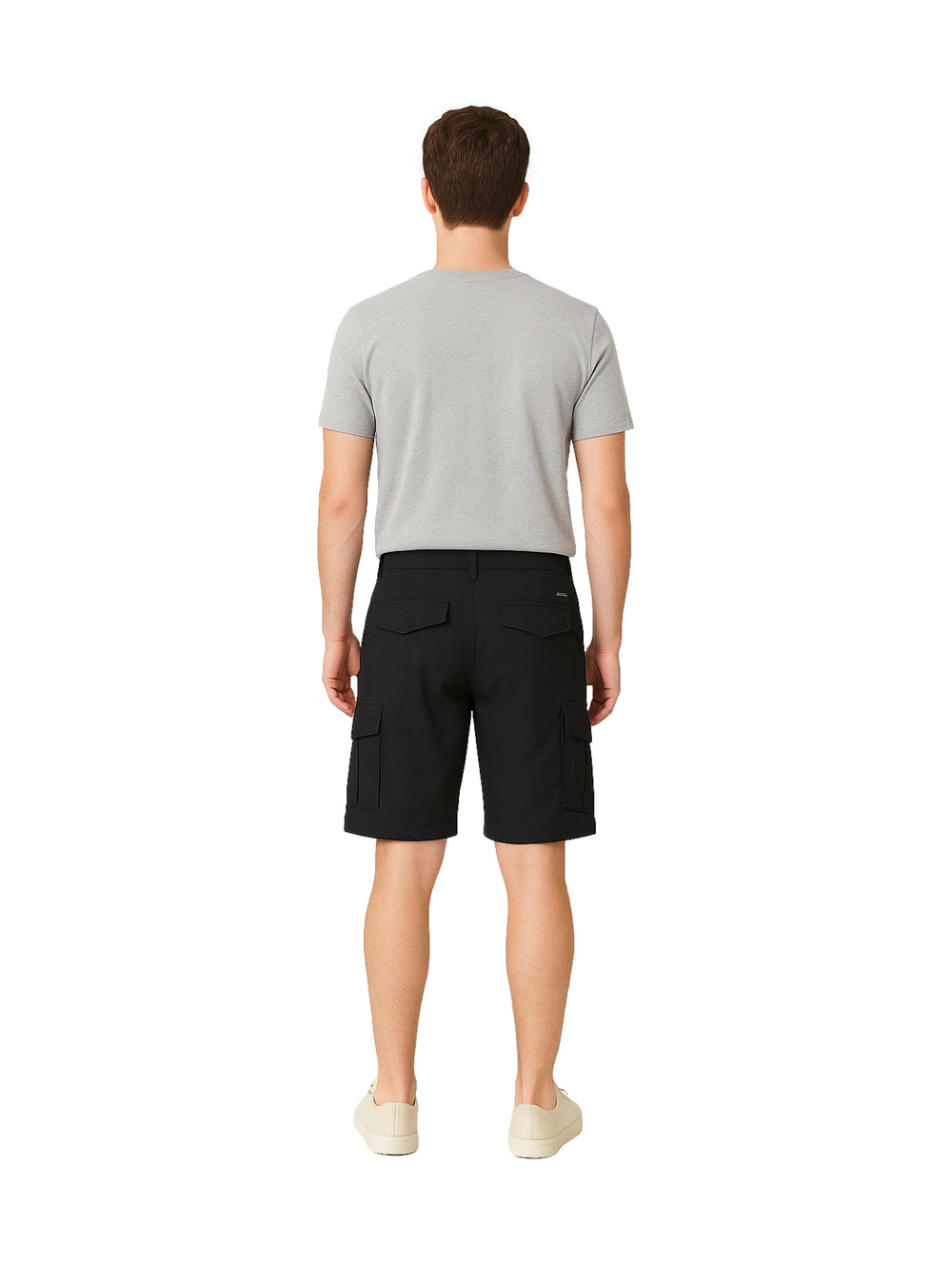 Hombre vistiendo shorts negros de surf con bolsillos laterales sobre fondo blanco.