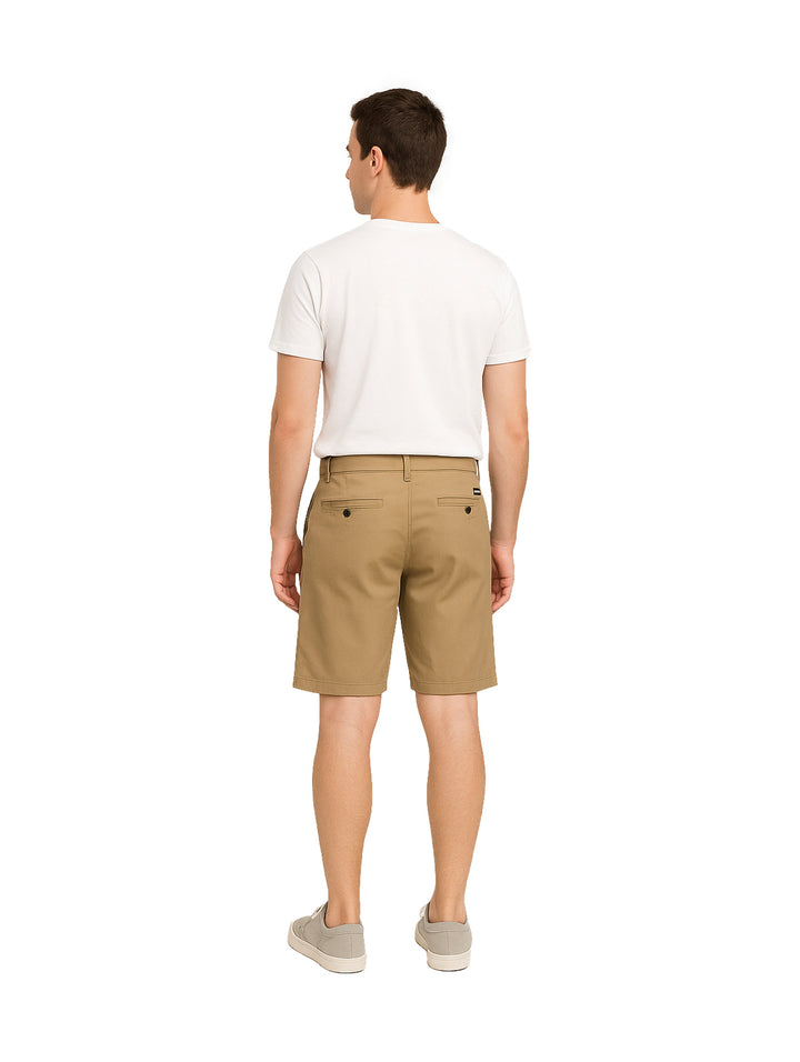 Hombre vistiendo shorts de gabardina color khaki y camiseta blanca sobre fondo blanco.
