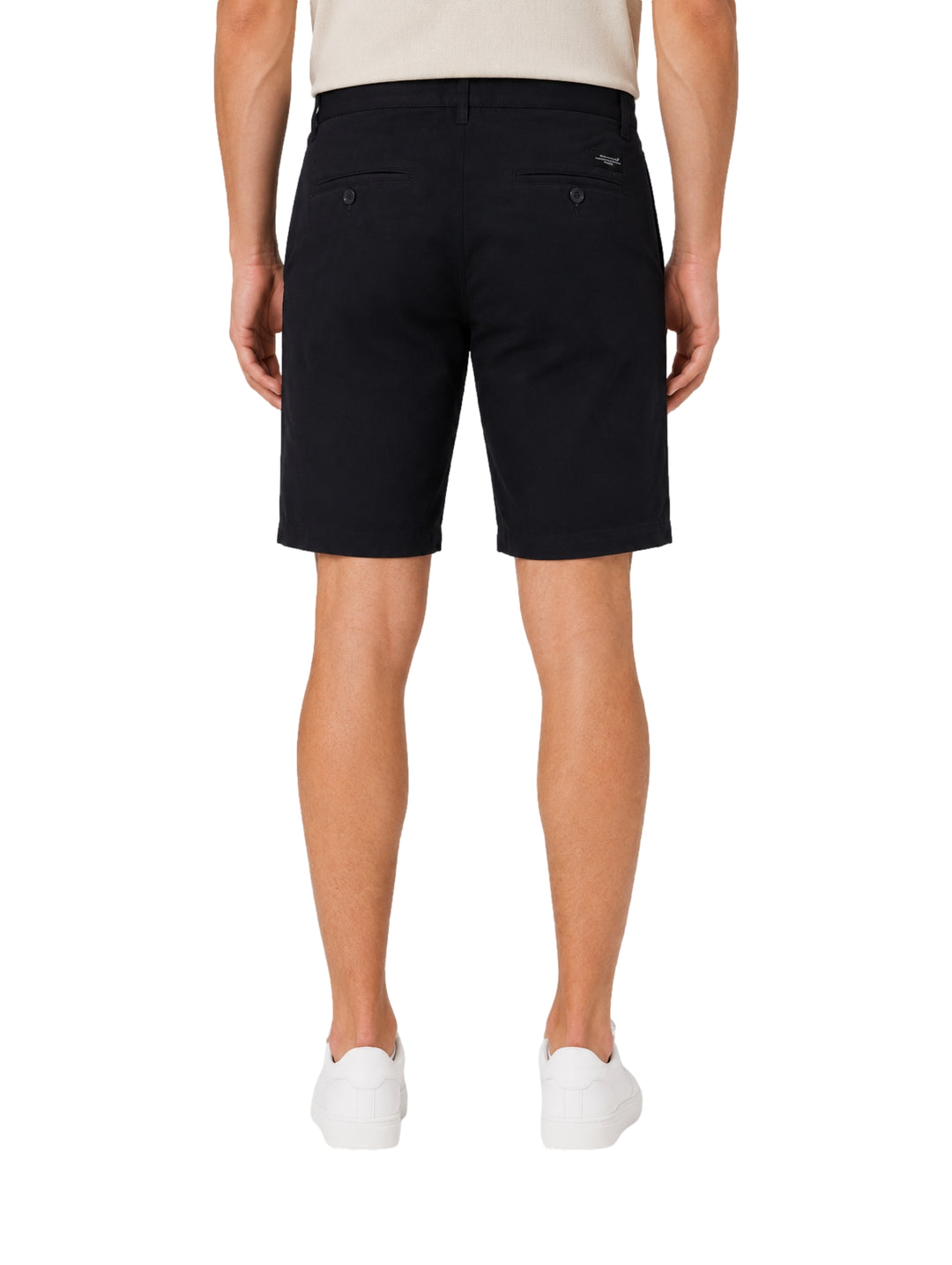 Hombre vistiendo shorts color navy de la marca Vertical Eagle y tenis blancos.