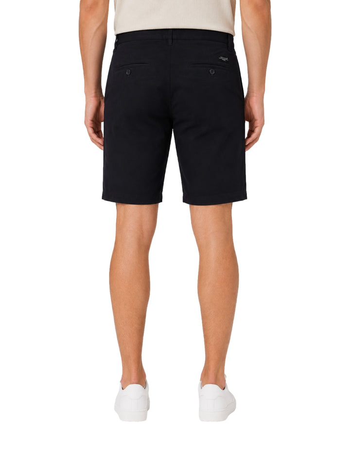 Hombre vistiendo shorts color navy de la marca Vertical Eagle y tenis blancos.
