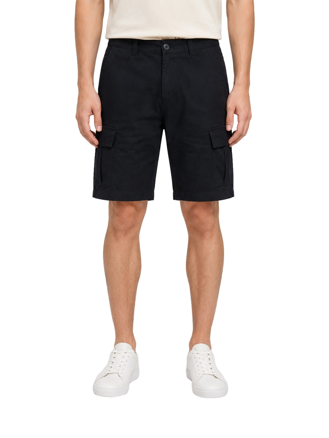 Hombre vistiendo shorts de surf color navy con bolsillos laterales y tenis blancos.