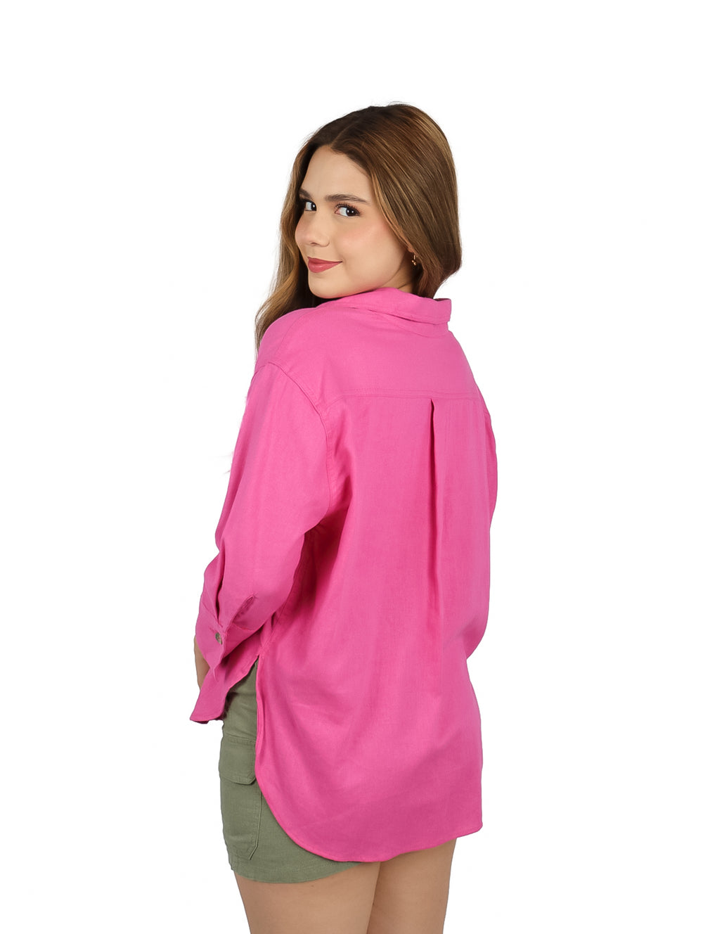 Mujer vistiendo una blusa camisera de color rosa con botones frontales y manga larga.