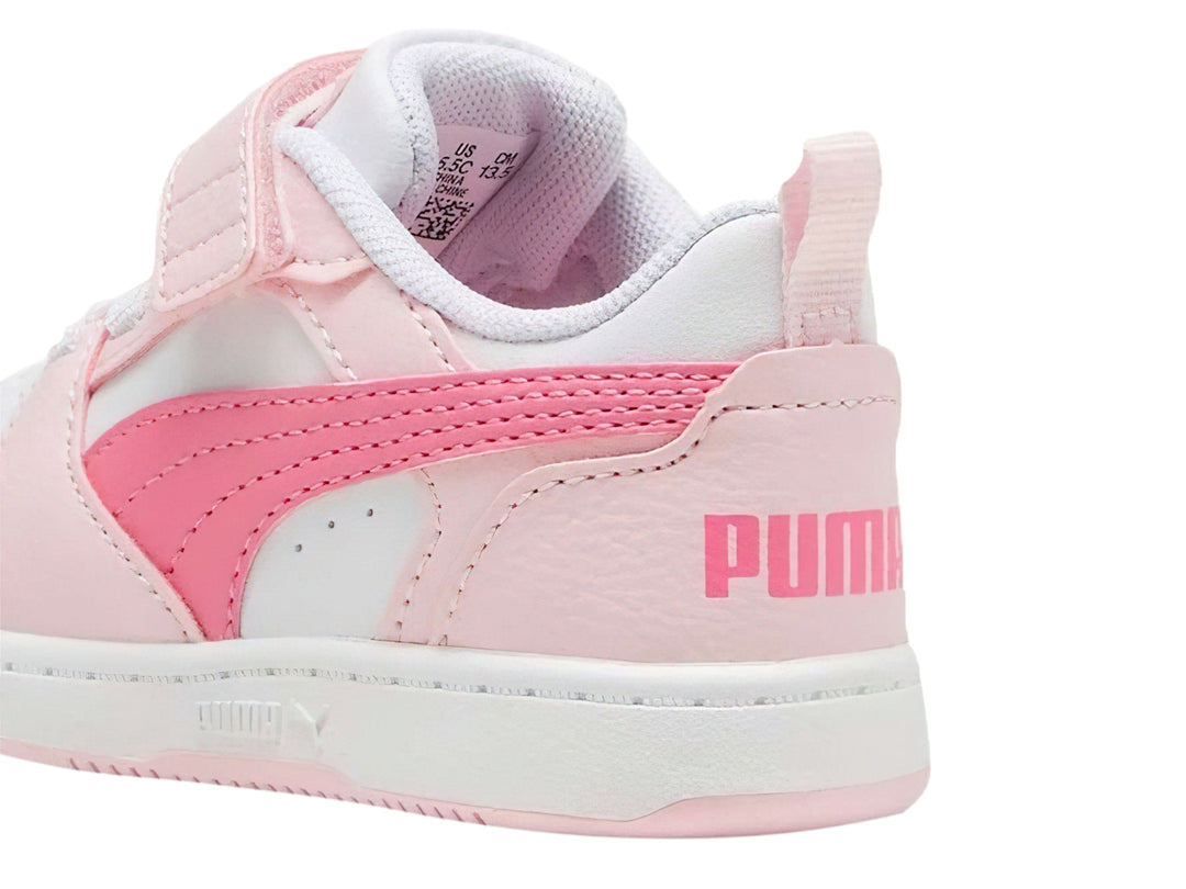 Tenis PUMA Rebound V6 Lo AC+PS para niña en colores blanco y rosa con cierre de velcro y agujetas.