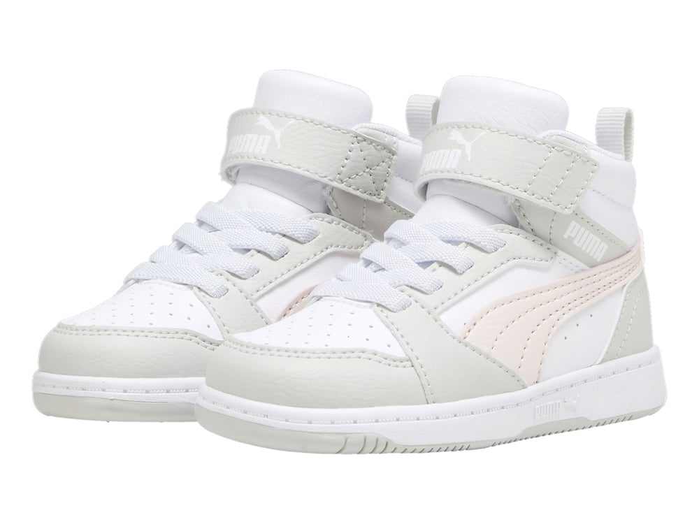 Tenis PUMA Rebound V6 Mid infantiles en colores blanco, gris y rosa con correa de velcro.