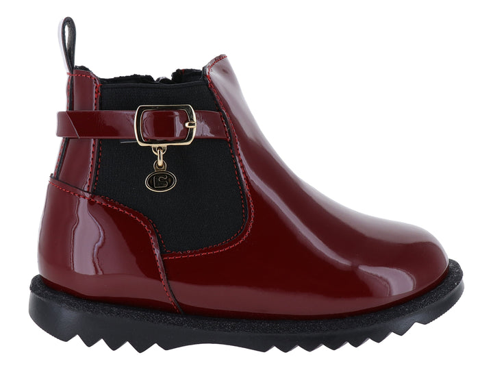 Botín rojo de charol con suela negra dentada y detalle de hebilla dorada.