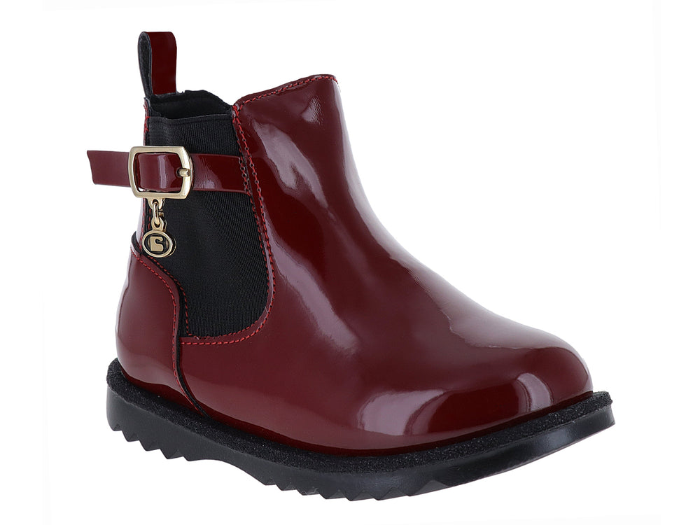 Botín rojo de charol con suela negra dentada y detalle de hebilla dorada.