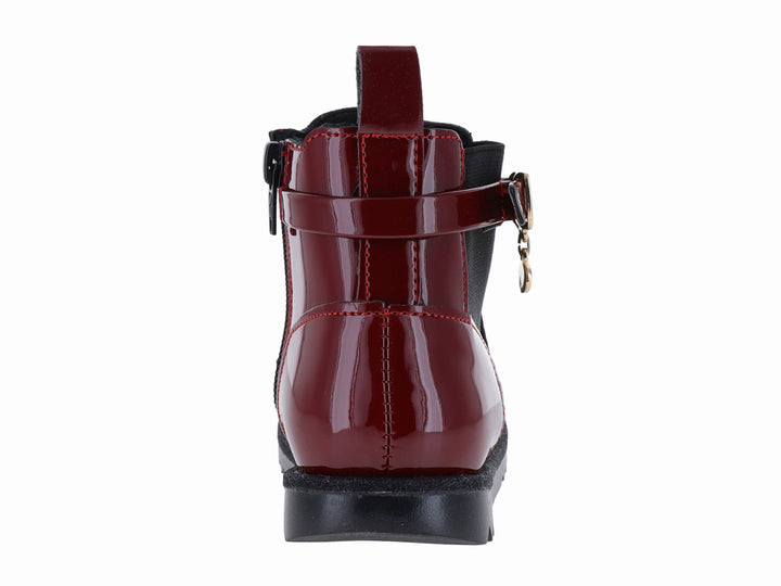 Botín rojo de charol con suela negra dentada y detalle de hebilla dorada.