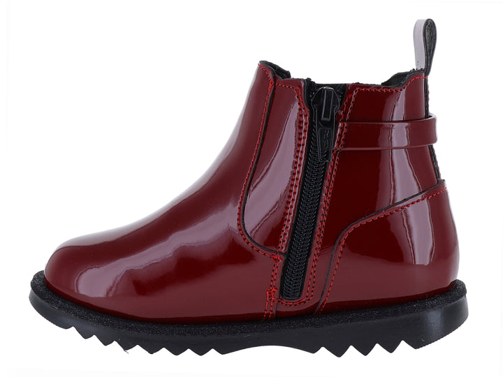 Botín rojo de charol con suela negra dentada y detalle de hebilla dorada.