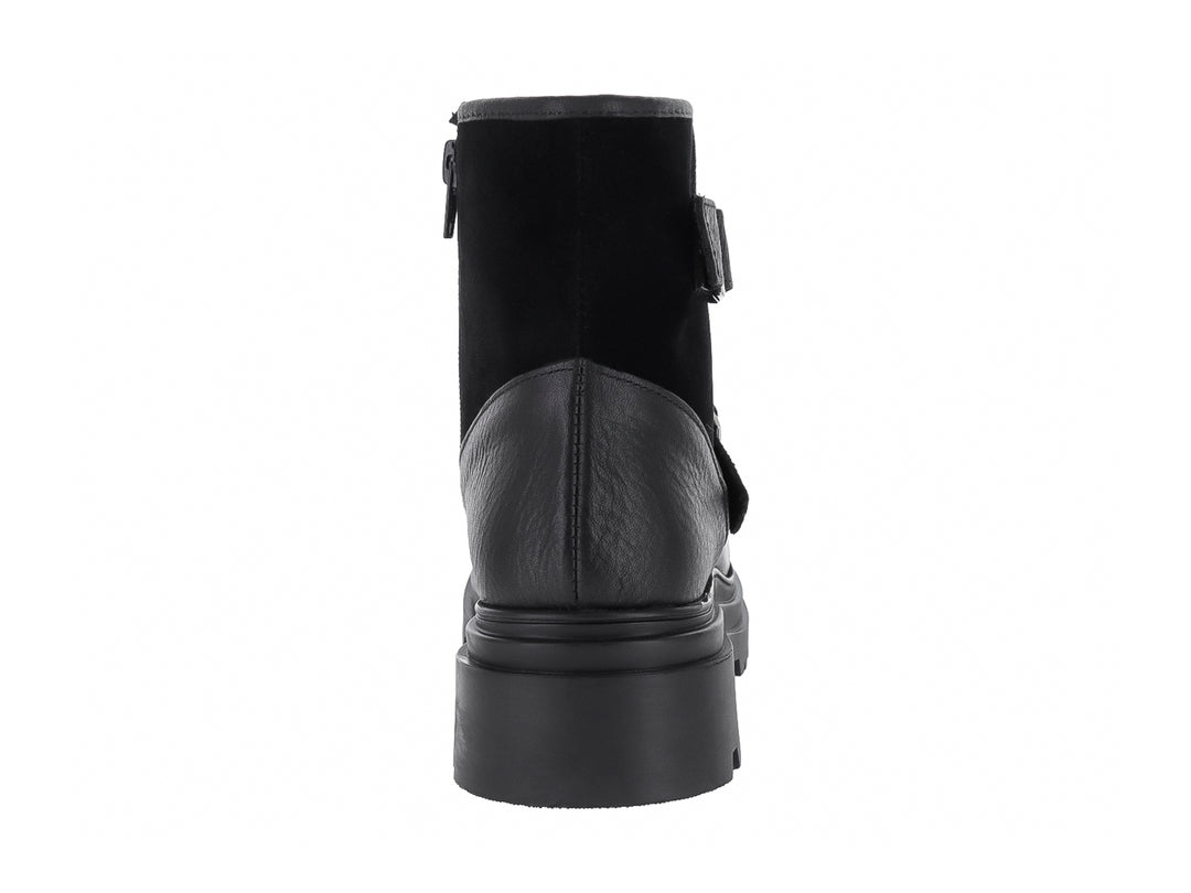 Bota negra de piel con suela track y dos hebillas plateadas.