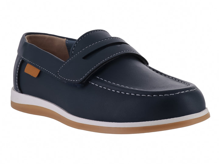Zapato tipo mocasín color azul marino para niño con suela blanca y detalles en color miel.