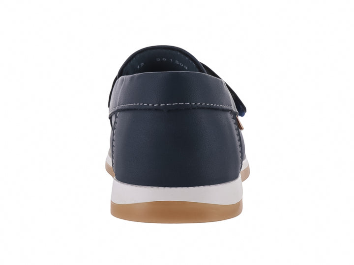 Zapato tipo mocasín color azul marino para niño con suela blanca y detalles en color miel.