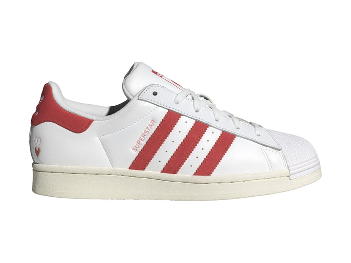 Tenis Adidas Superstar blancos con tres franjas rojas laterales y detalle rojo en el talón.