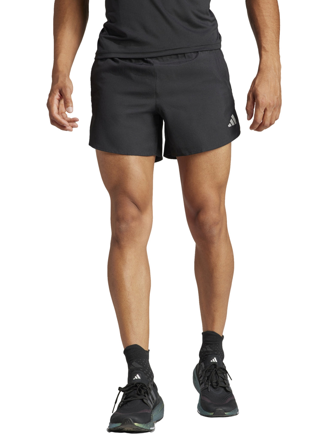Hombre vistiendo shorts deportivos Adidas color negro de corte corto para correr.
