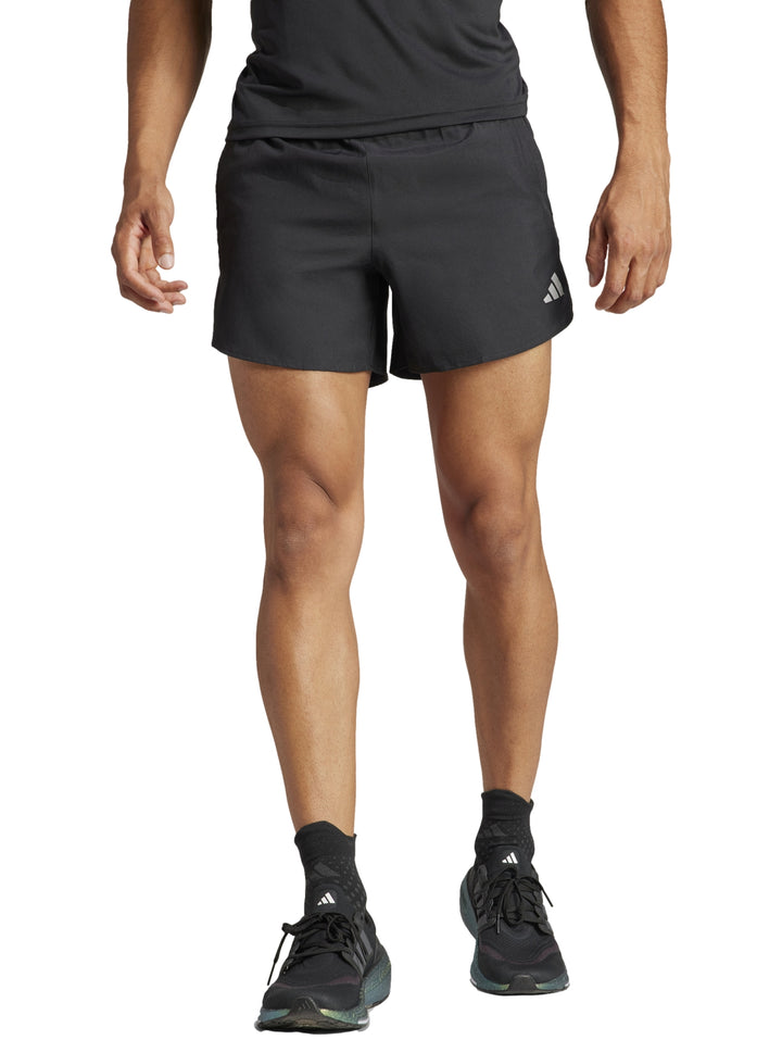 Hombre vistiendo shorts deportivos Adidas color negro de corte corto para correr.