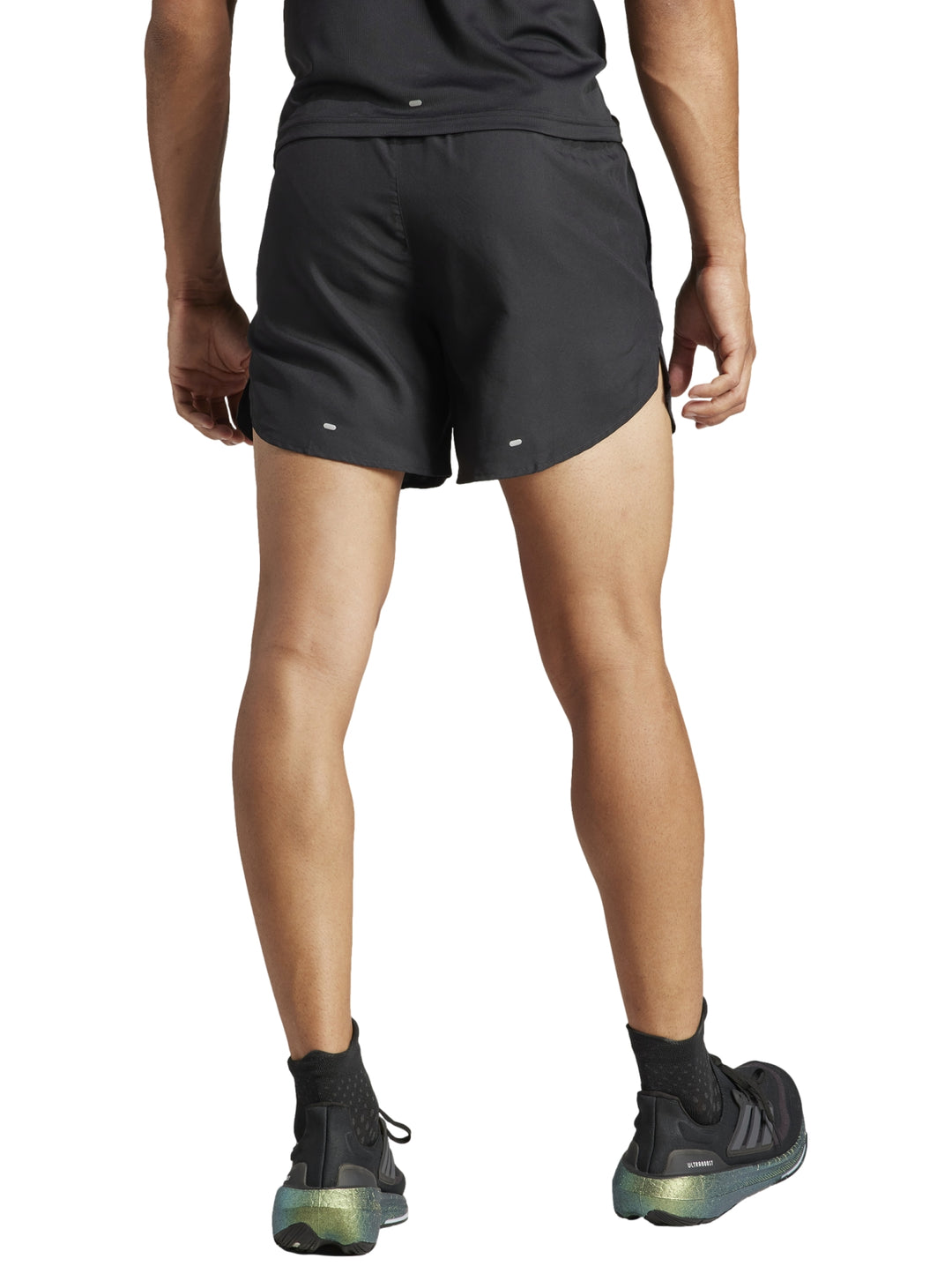 Hombre vistiendo shorts deportivos Adidas color negro de corte corto para correr.