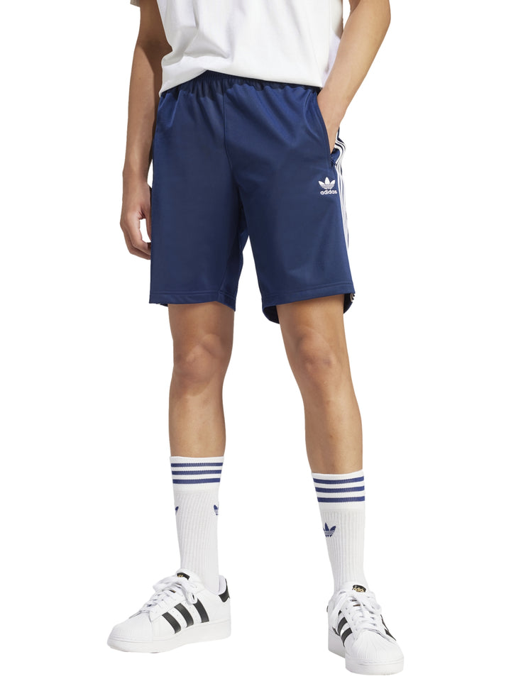 Shorts deportivos Adidas Firebird en color azul Night Indigo con rayas blancas laterales y logo bordado.