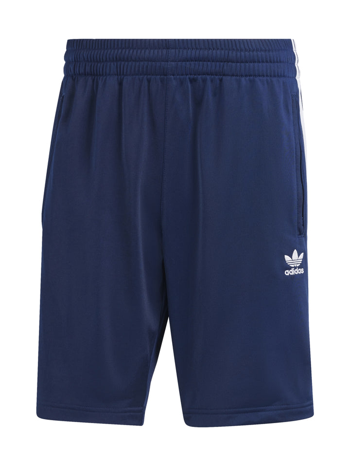 Shorts deportivos Adidas Firebird en color azul Night Indigo con rayas blancas laterales y logo bordado.