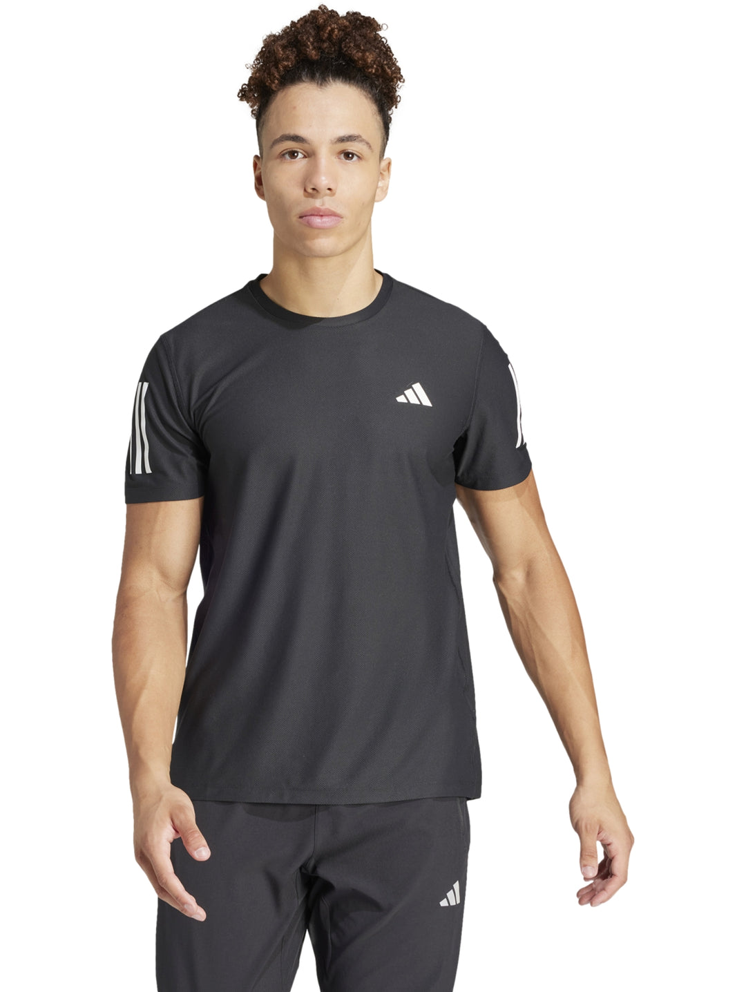 Hombre vistiendo playera deportiva Adidas de color negro con detalles blancos en mangas y pecho.