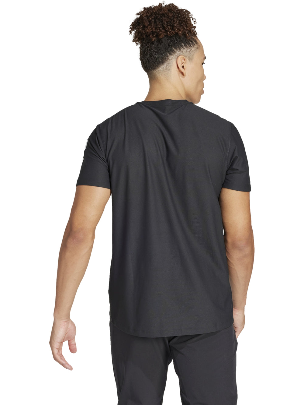 Hombre vistiendo playera deportiva Adidas de color negro con detalles blancos en mangas y pecho.