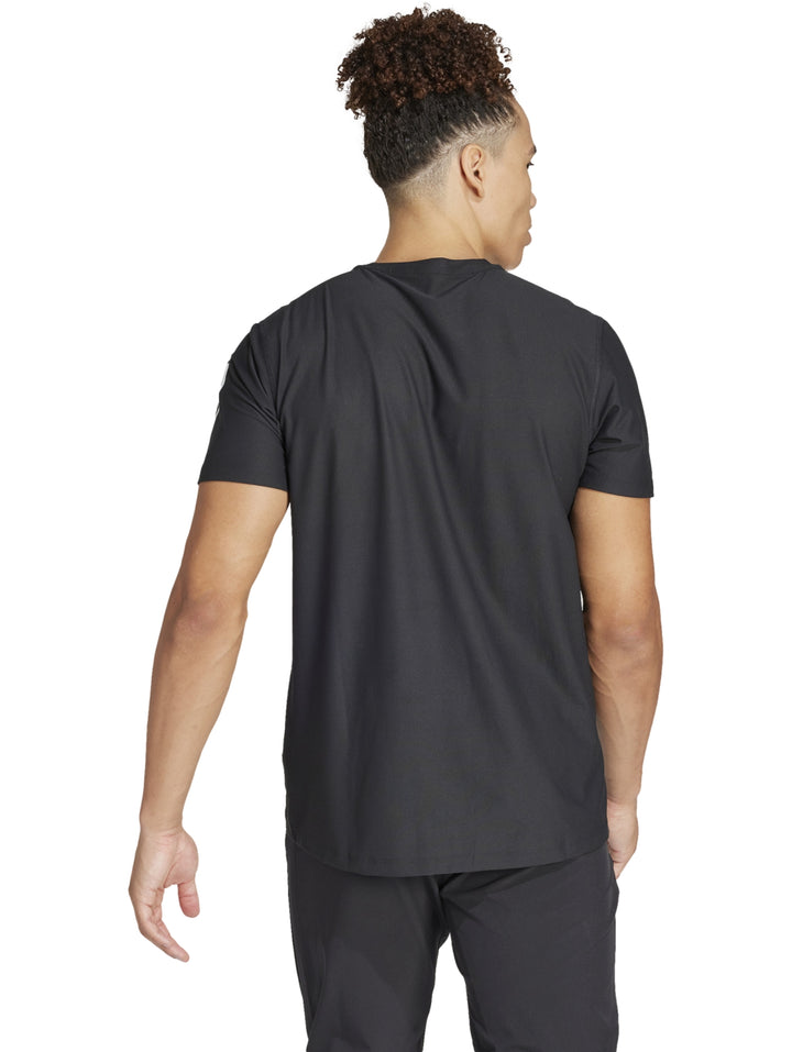Hombre vistiendo playera deportiva Adidas de color negro con detalles blancos en mangas y pecho.